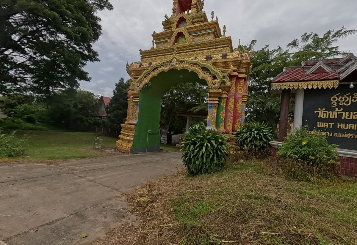 Green-and-gold gate arch beside the name board