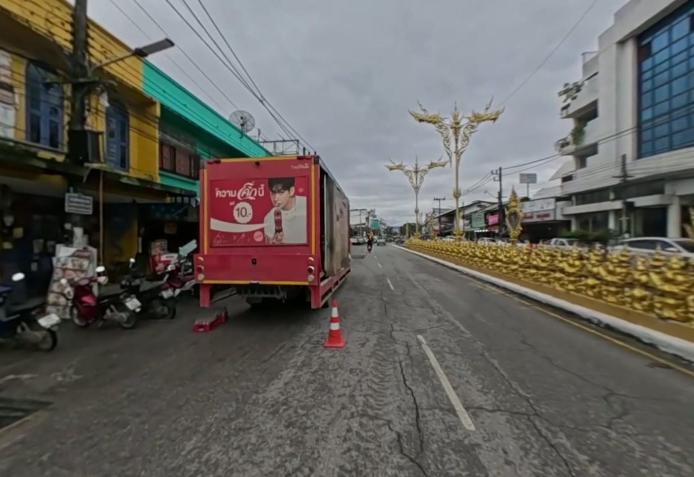 Old painted shophouses and the golden median of the road leading from the clock tower