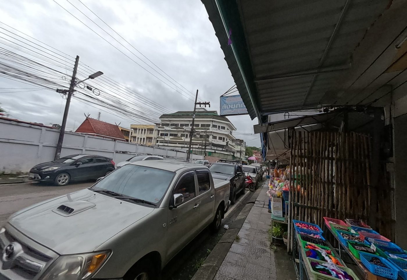 Street stall of ribbons and craft goods under the monks'-supplies shop sign