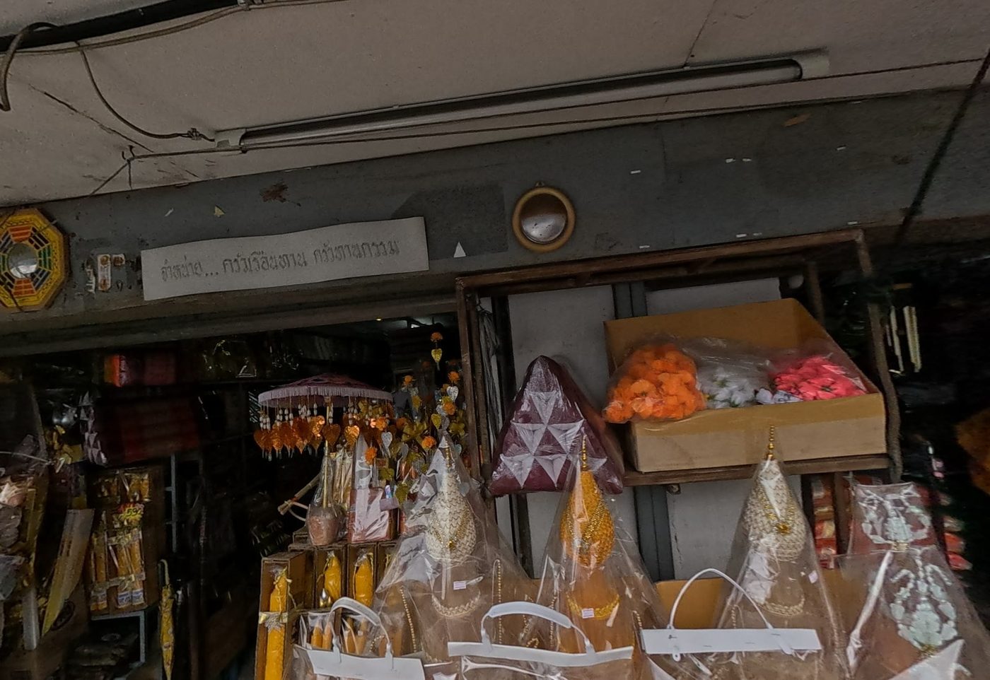 Monks' offering sets, candles and paper parasols stacked at a shop front