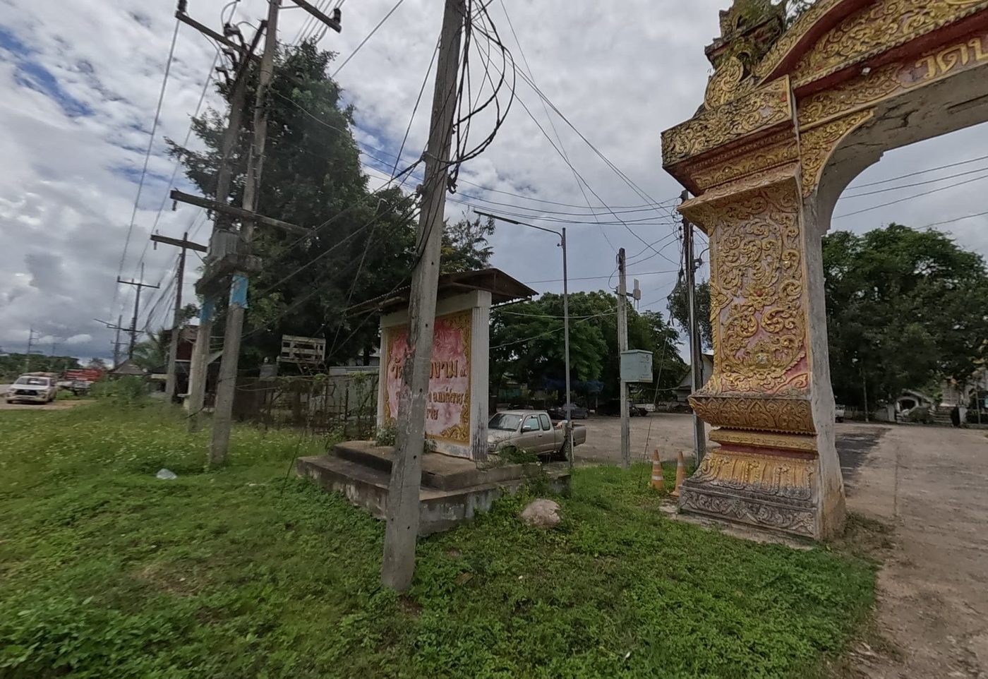 Gilded gate arch and roadside name board