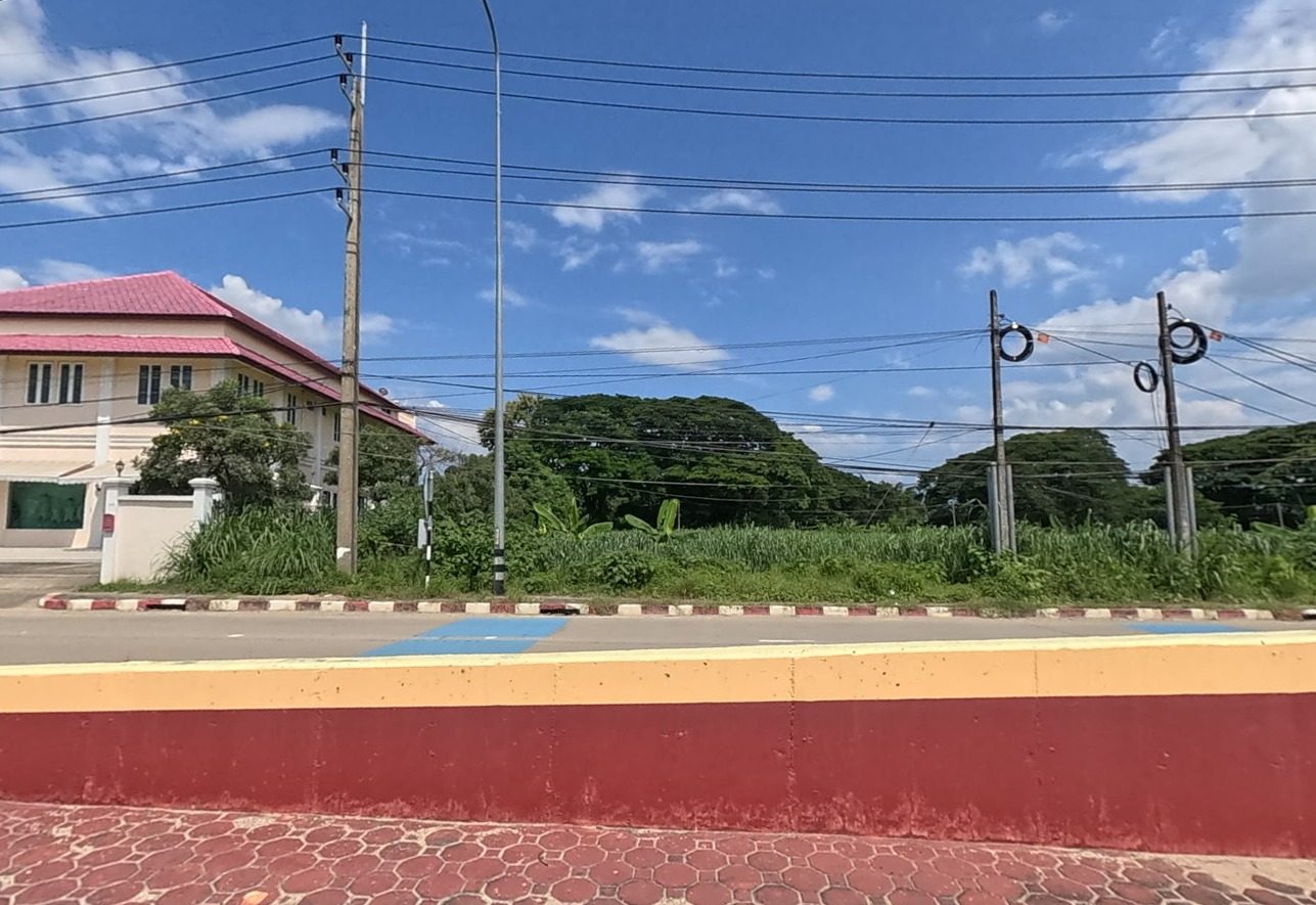 White two-storey building with a red roof beside the highway