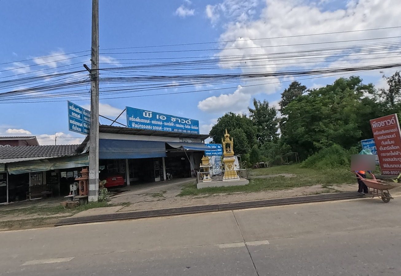 Roadside shrine in front of a row of shops