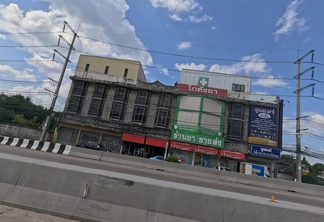 Old three-storey building with a wholesale pharmacy in a green-framed shopfront
