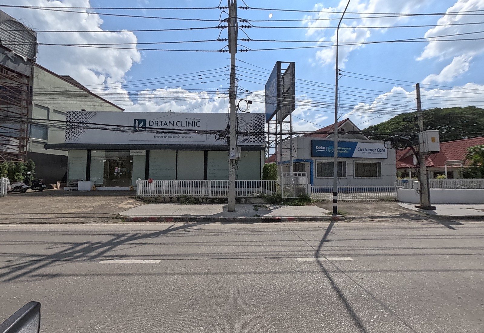 DR.TAN CLINIC, a skin and laser clinic behind a white fence, stands beside a Beko Customer Care office.
