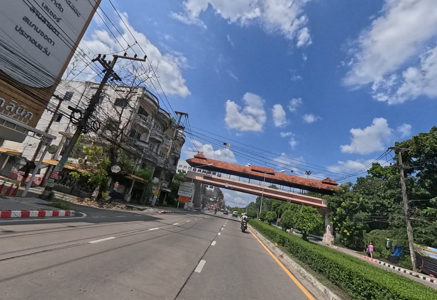 Road ahead passing under a Lanna-style roofed footbridge