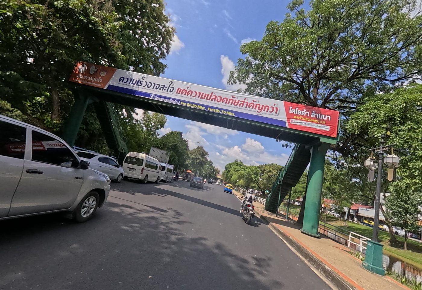 Moat road with a banner arch over it and shade trees