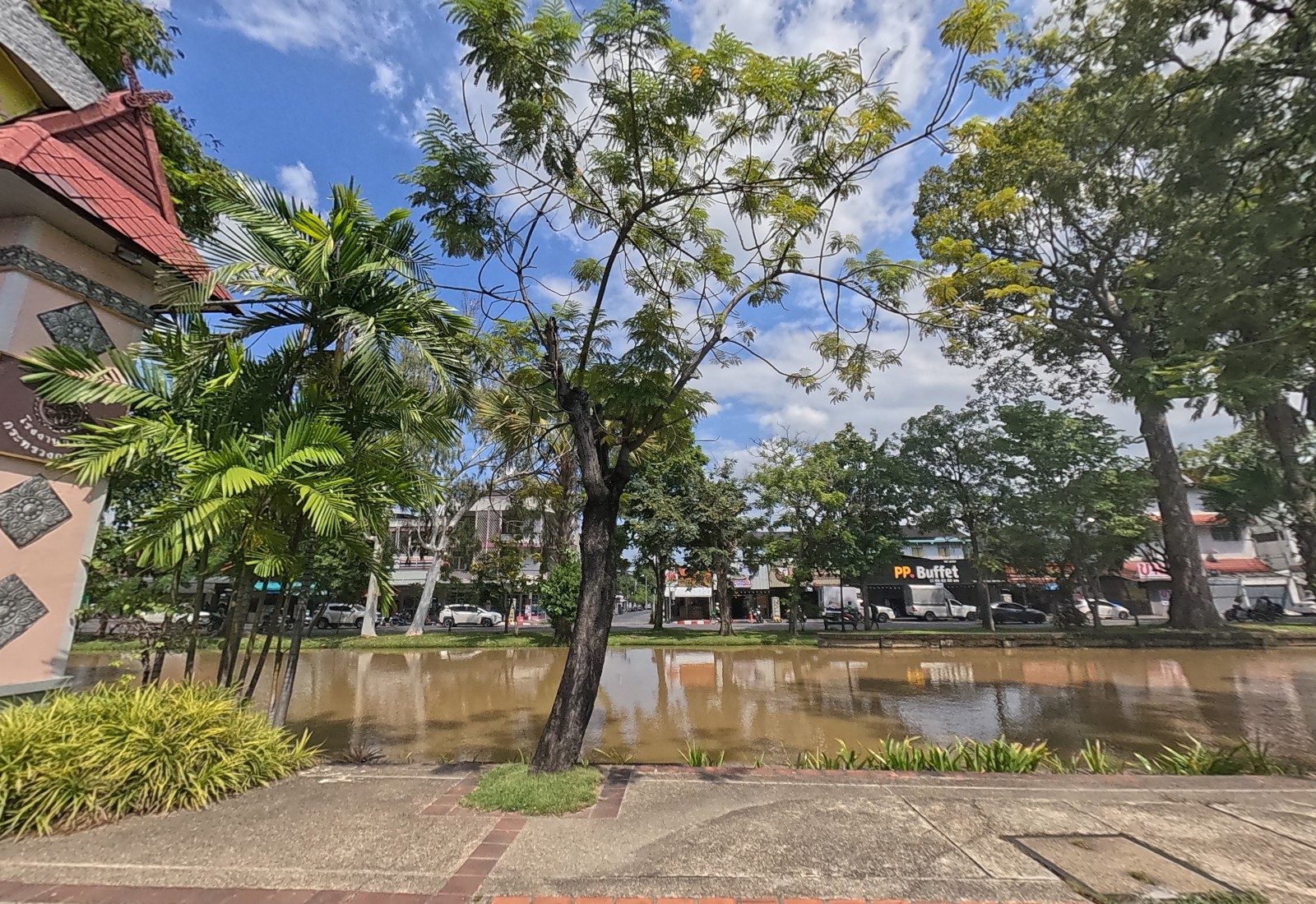 Across the moat, a row of shophouses with the PP. Buffet sign; the arch pillar at left.