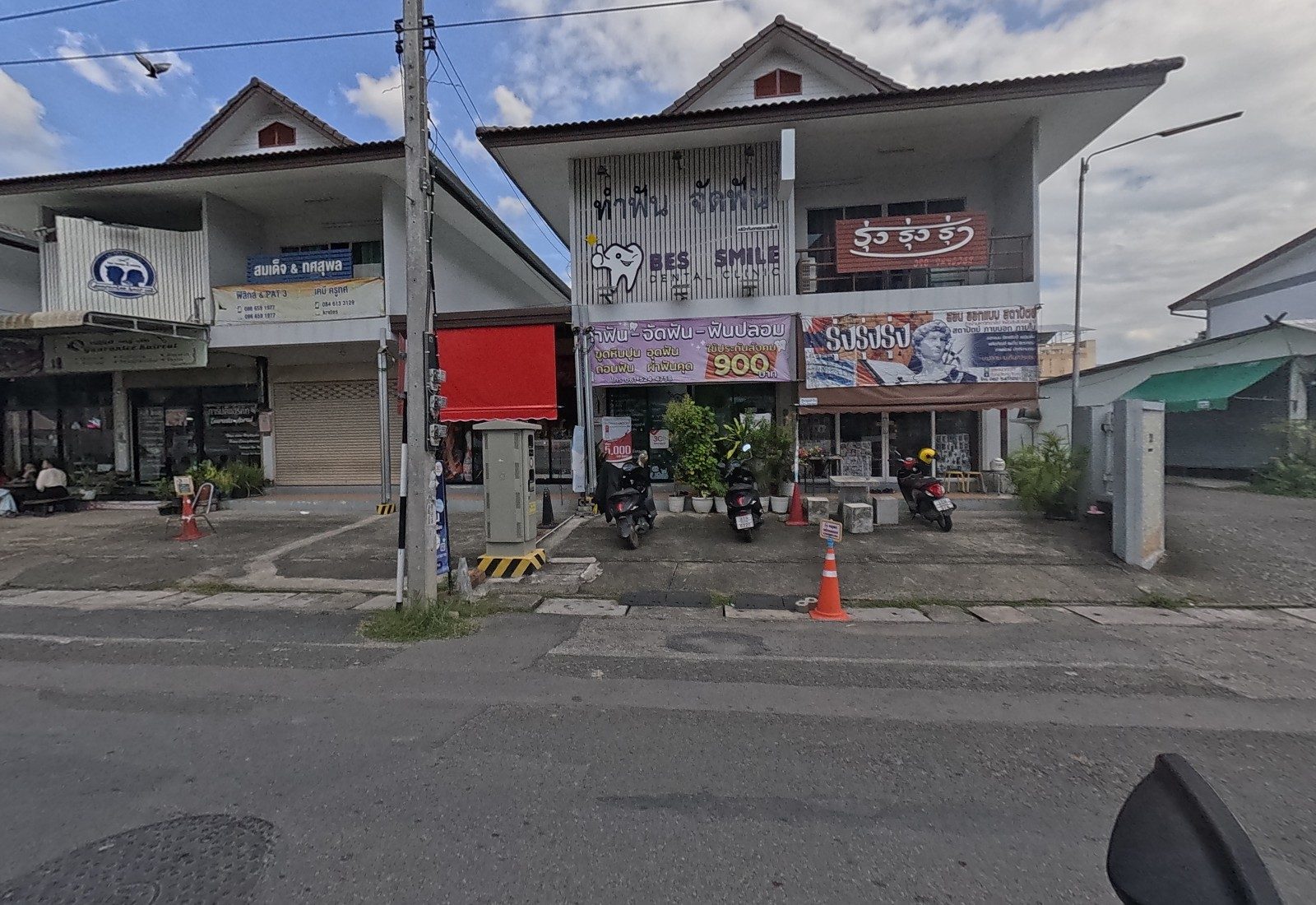 Guarantee Haircut, the tutor signs for physics and chemistry, a red-awninged shop, and the Bes Smile clinic with the Rung Rung Rung banner.