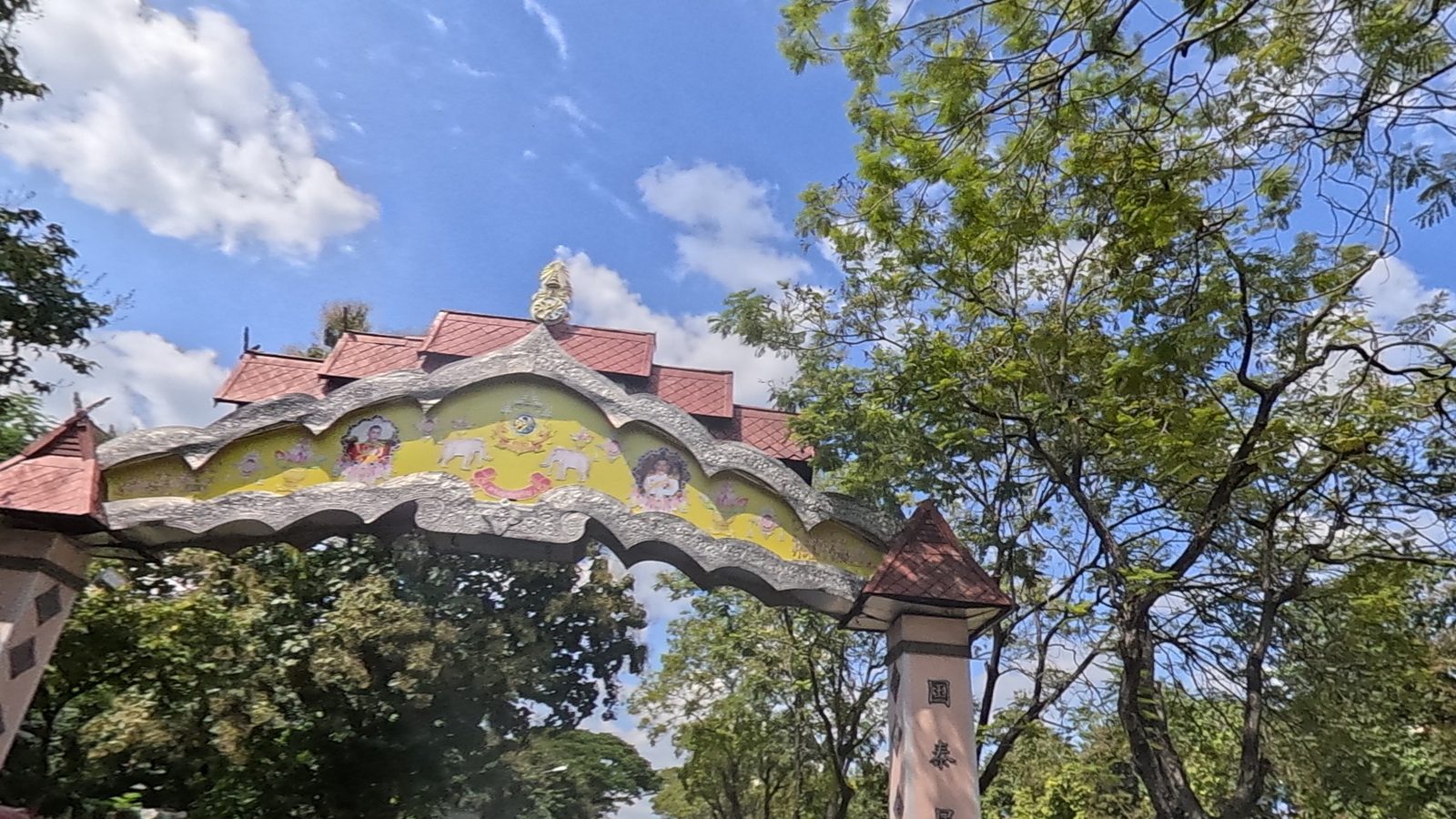 Ornate red-roofed gate arching the road