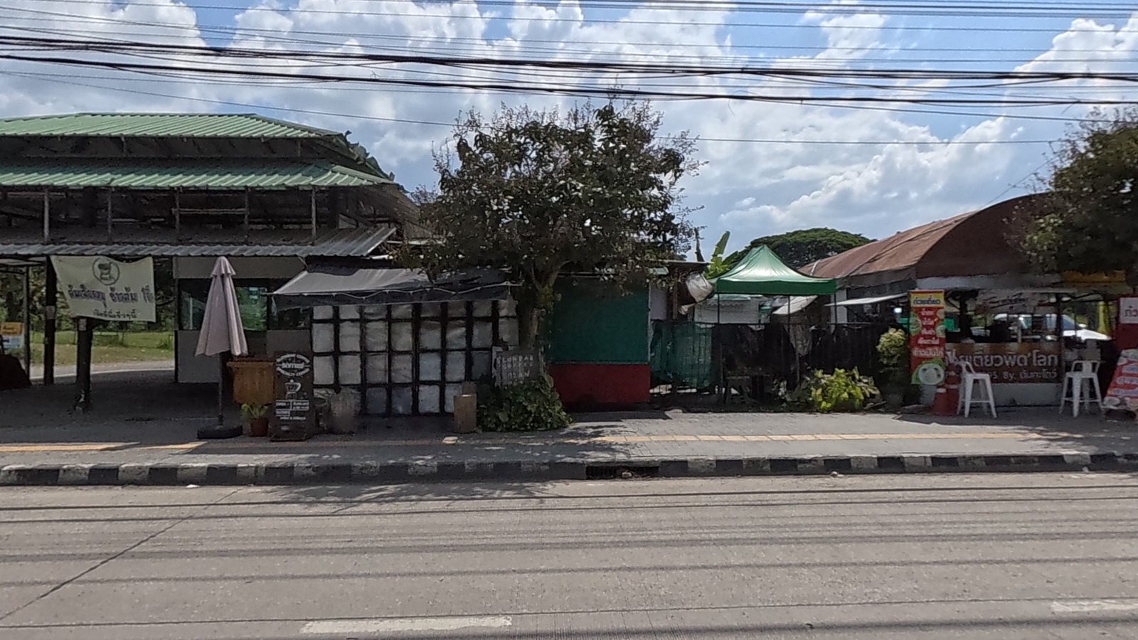 Roadside food stalls under tin roofs