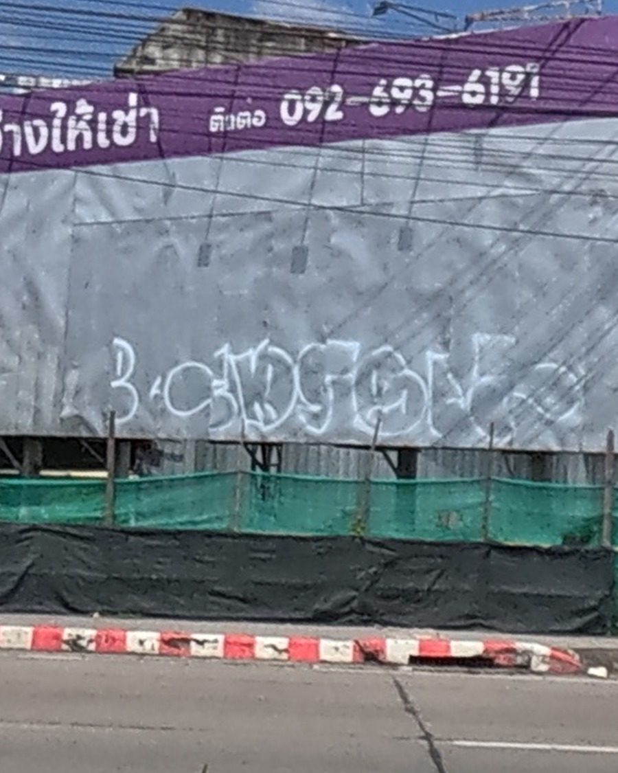 White spray tag on a blank grey billboard face