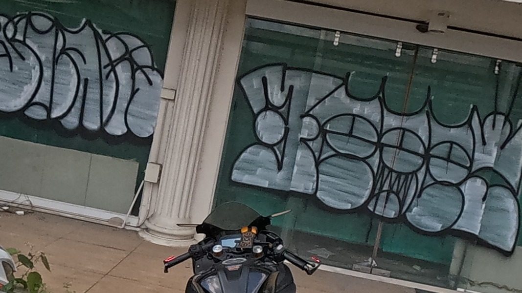 Twin bubble-letter tags on shopfront glass