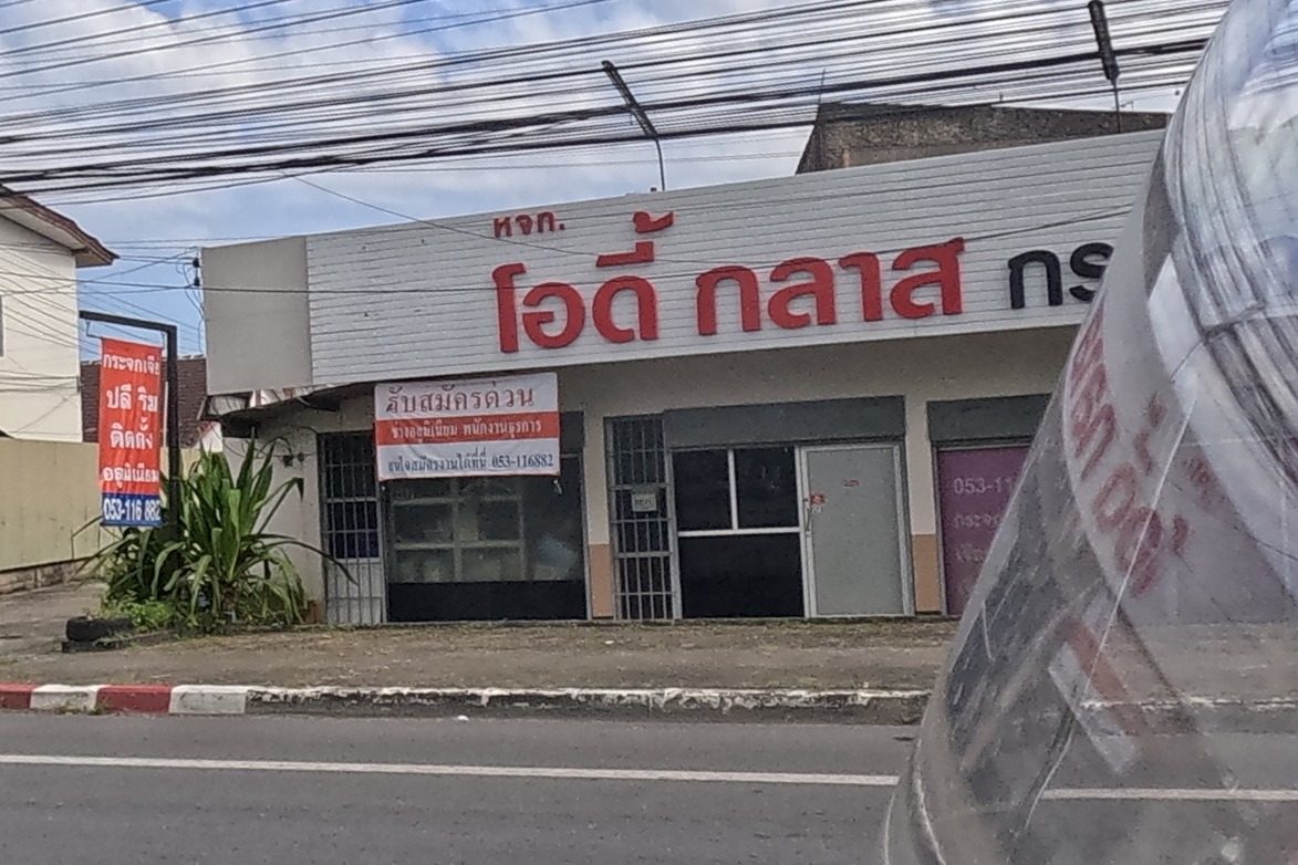 Across the road, a glass and mirror shop called Odee Glass with a hiring notice, next to another shop partly reading Jia Plee.