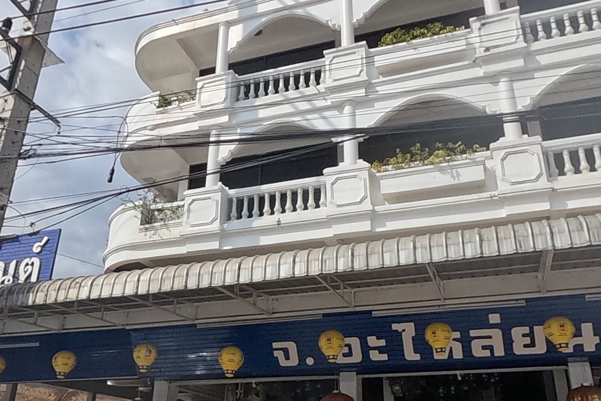 The 'J. Auto Parts' shophouse is fully and clearly signed on a three-storey building with balloon-shaped light fixtures.