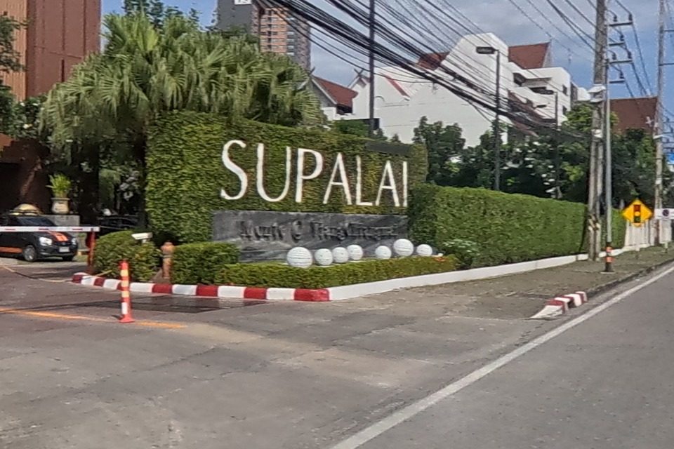 Supalai Monte Chiang Mai's main entrance shows its signage, a boom-gate barrier and a guard hut.