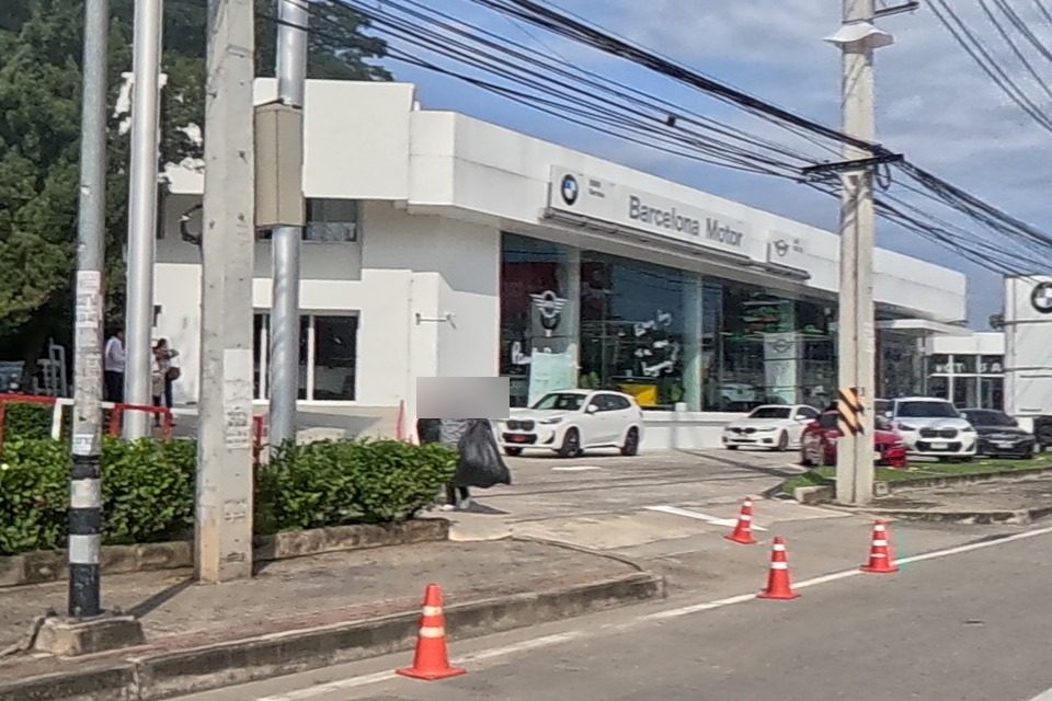 The BMW dealership building is now clearly labelled 'Barcelona Motor' beneath the BMW roundel, with several BMWs parked out front.