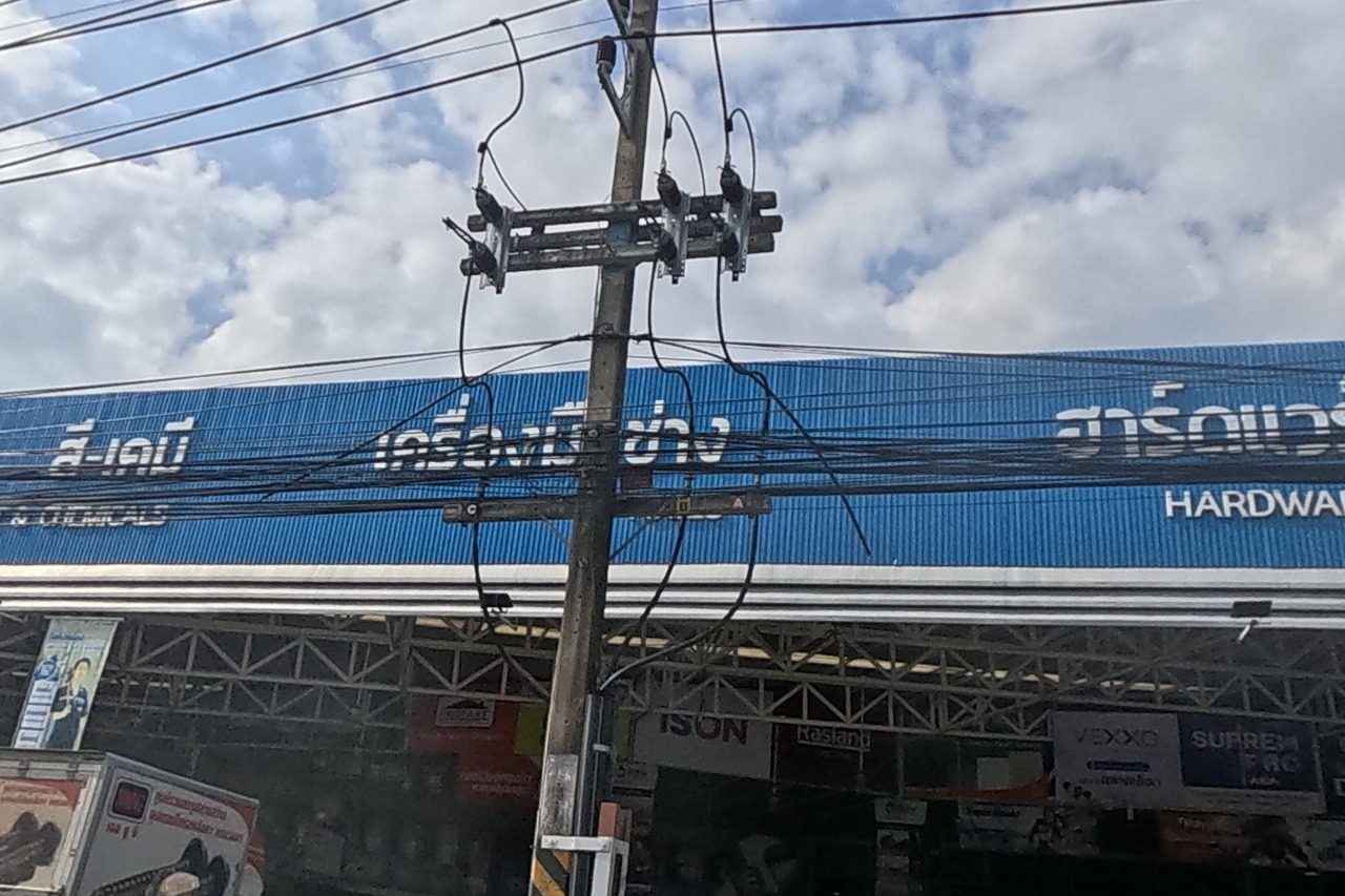 A long blue-roofed hardware megastore with signage for construction materials, paint and chemicals, and tools, brand boards for Weber and DOS visible.