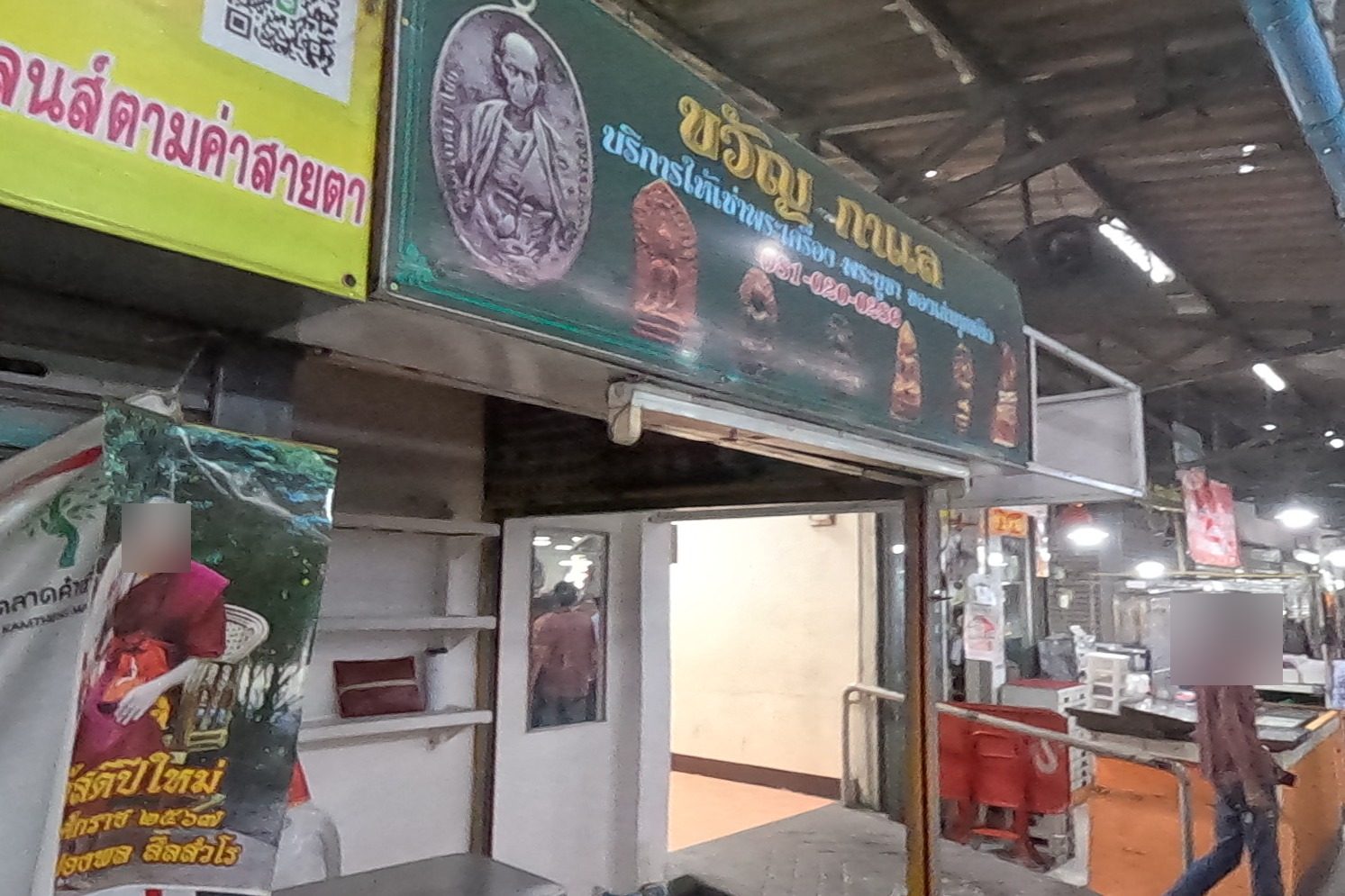 Khwan Kamol's open, empty unit under its green sign; the aisle of trays runs on under the 'ตลับพระ' banner.