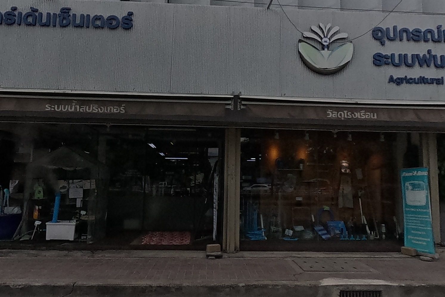 A garden-and-agricultural-equipment shop with a wide glass frontage, selling sprinkler systems and greenhouse supplies.