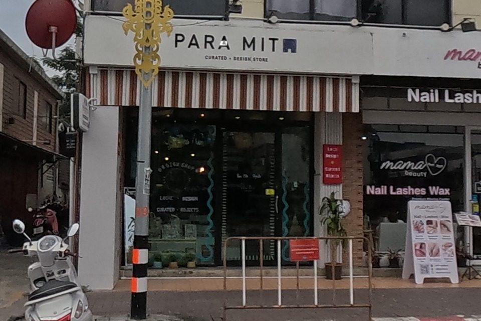 A row of small shops: a motorbike rental, a hair-color salon, a design store and a nail-and-lash salon.