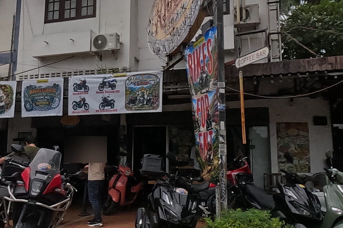 A motorbike shop with a fleet of rental bikes out front, signed for bike rental and a coffee bar.