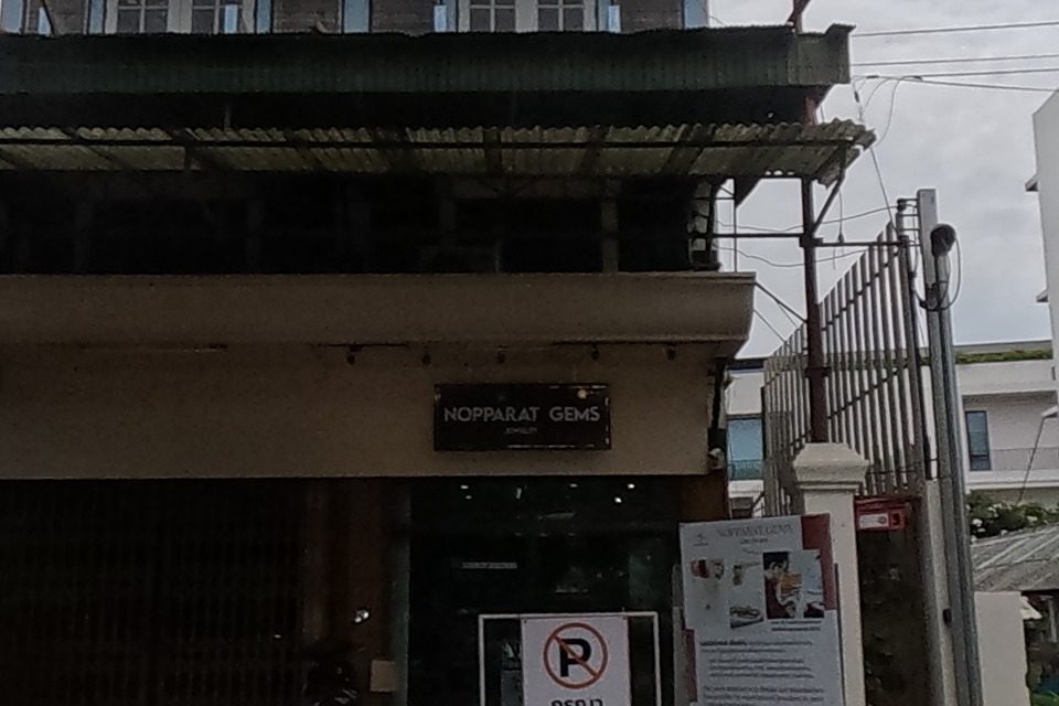 A boutique hotel and cafe next to a jewellery shop called Nopparat Gems.