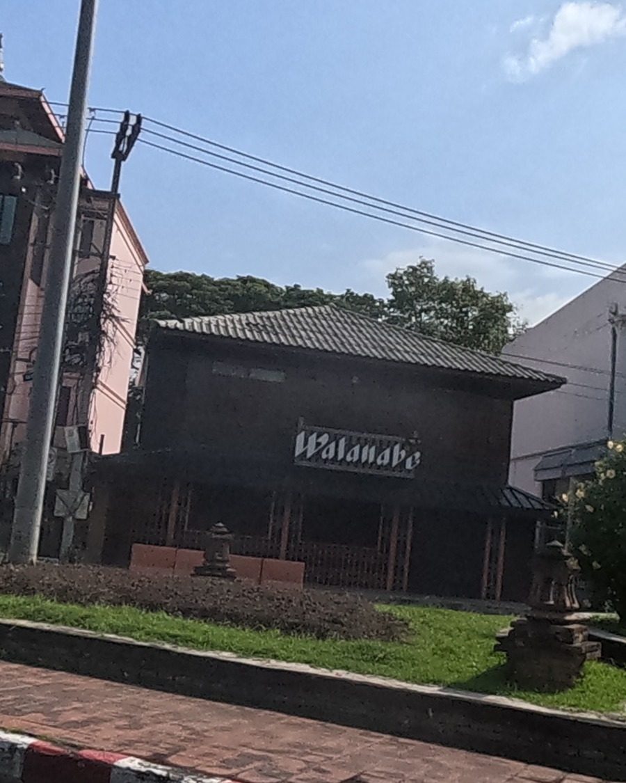 Dark teak building with the Watanabe sign