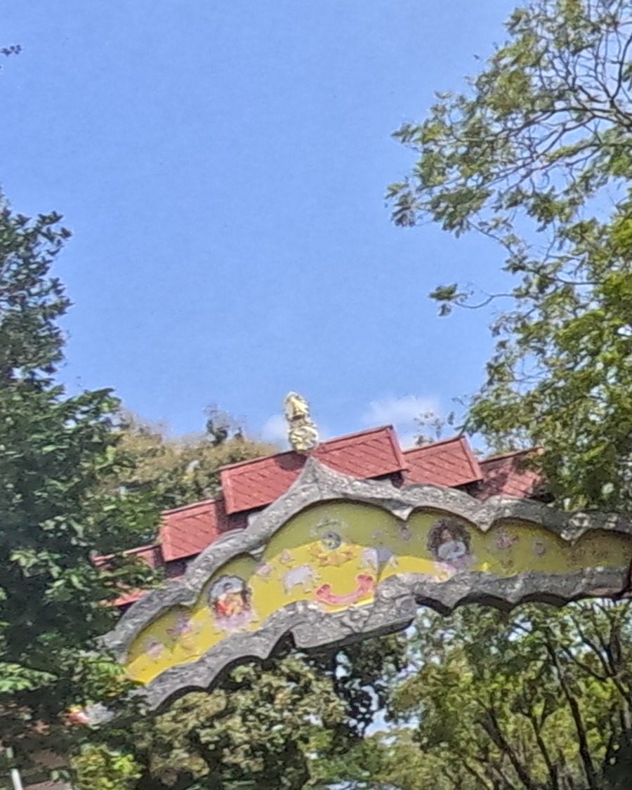 Ornate red-and-gold memorial arch over the avenue