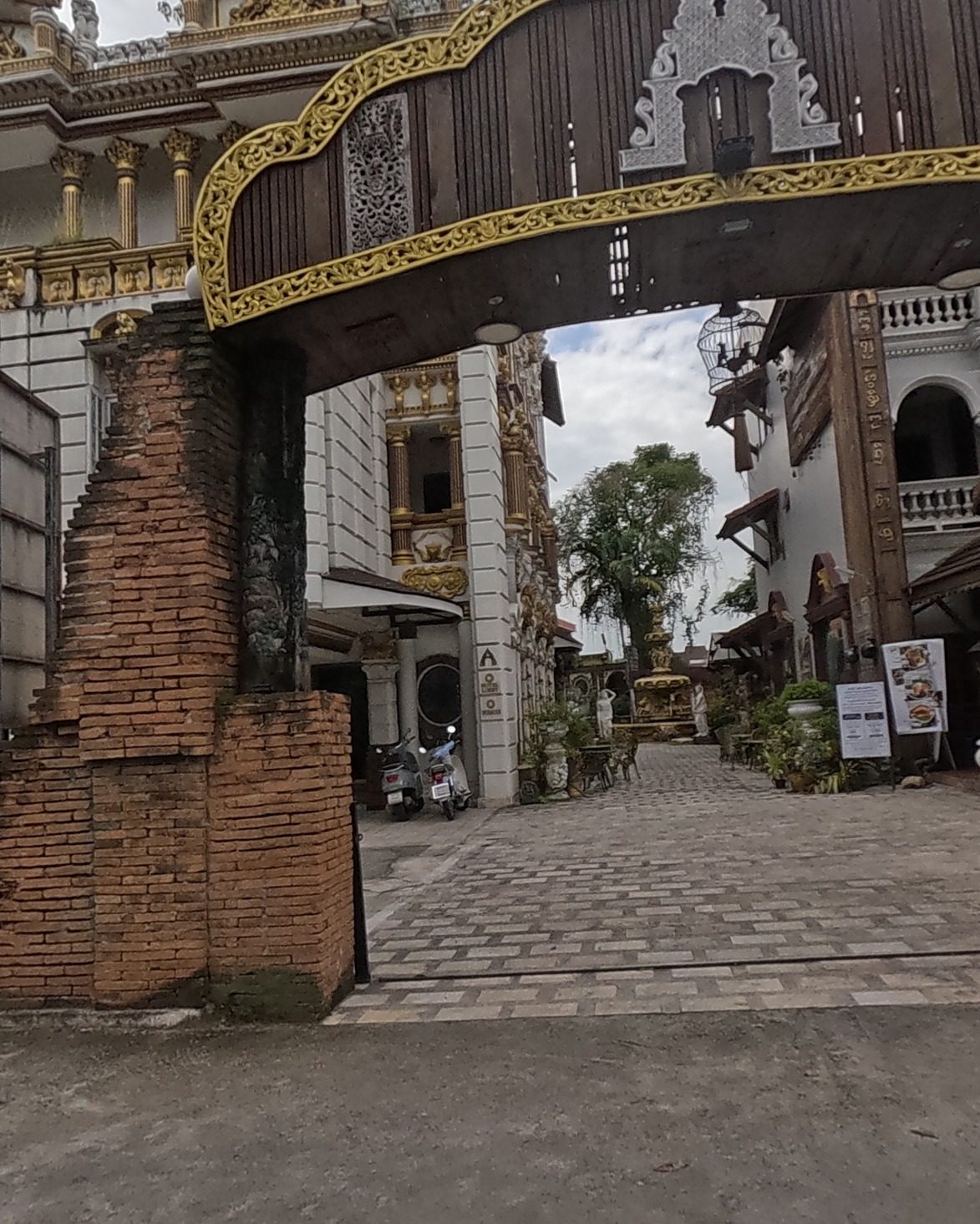 Gold-trimmed brick gateway into an opulent courtyard