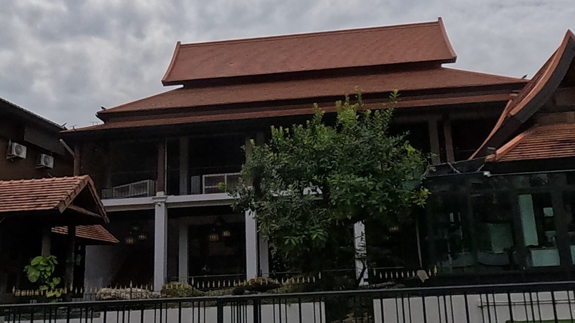 Lanna teak house behind iron fence