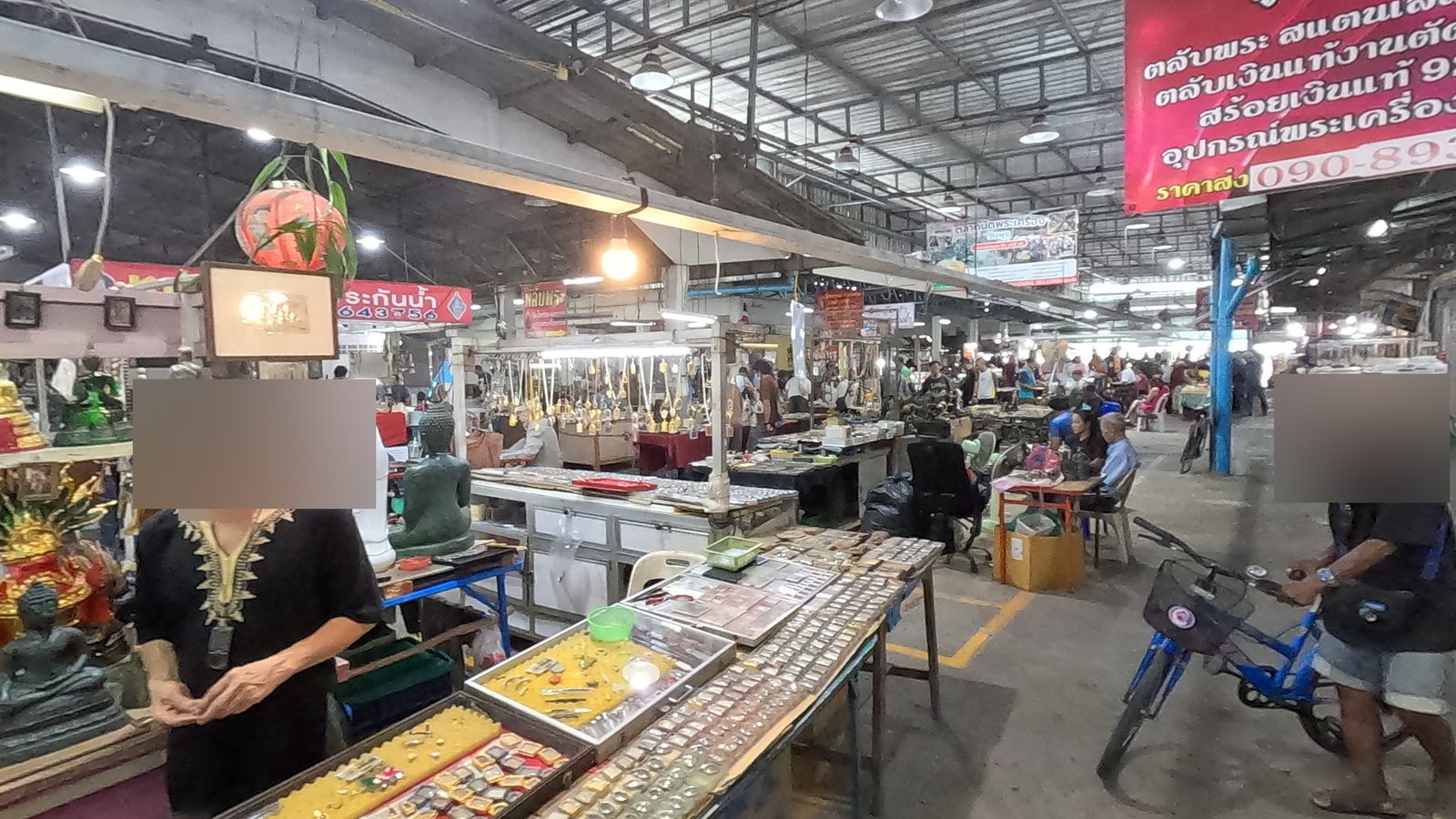 A dealer counts amulets as the aisle fills
