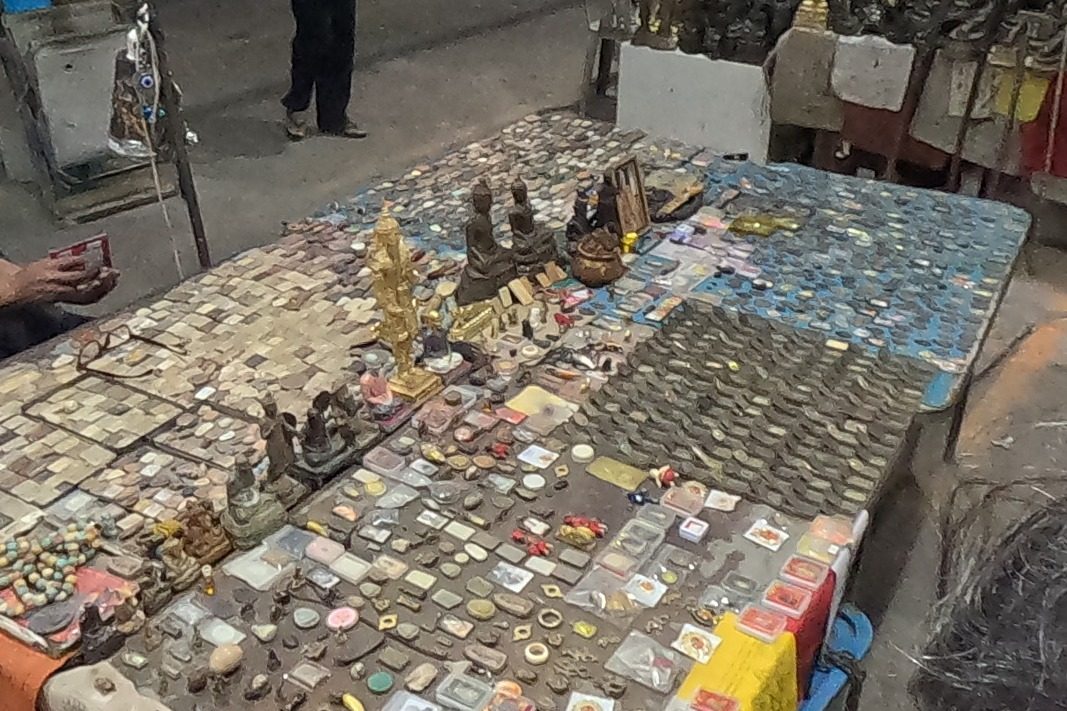 A table covered in clay amulets and small bronzes