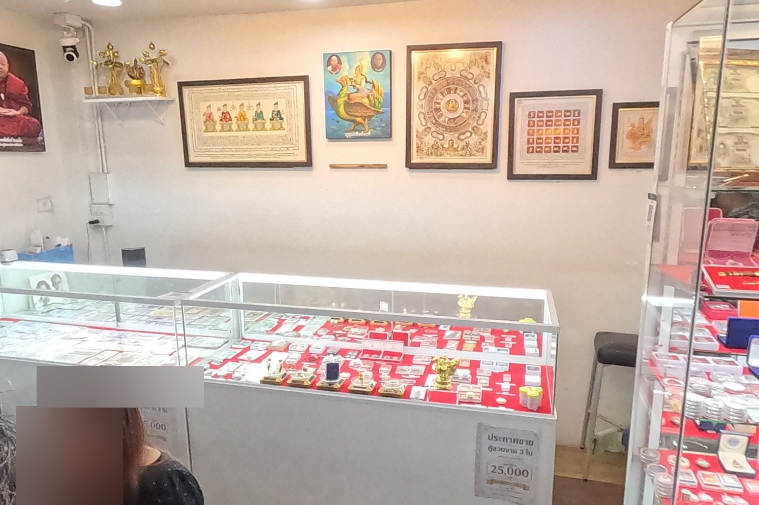 Inside an amulet shop: lit cases and framed yantra