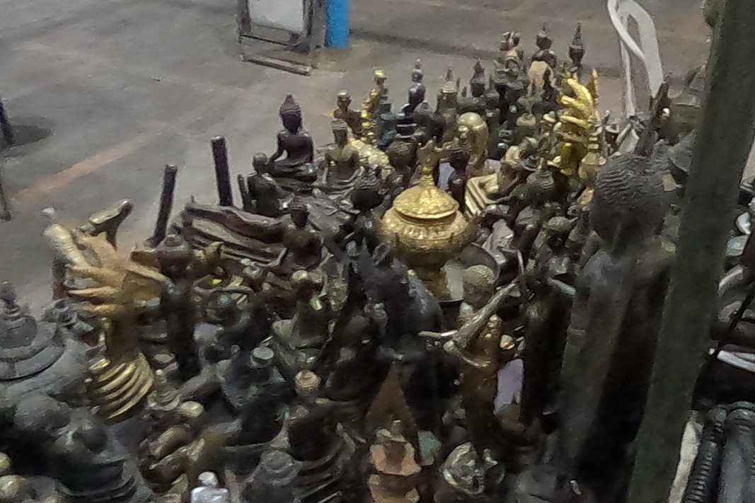 Bronze Buddhas, naga figures and a gilt urn