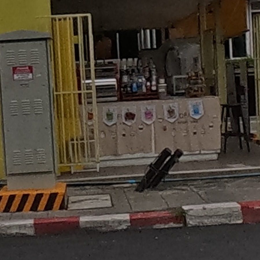 Miniature spirit-house shrines for sale on a sidewalk step