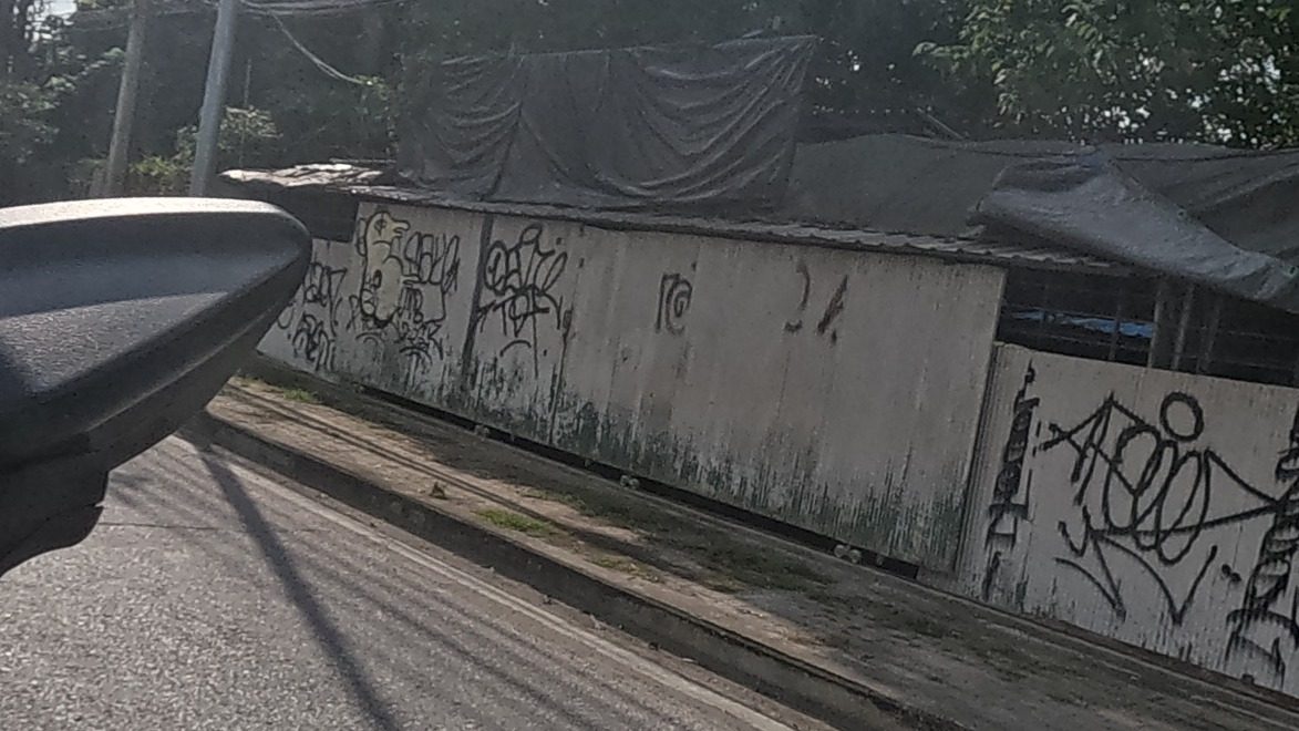 black spray tags on a corrugated metal fence