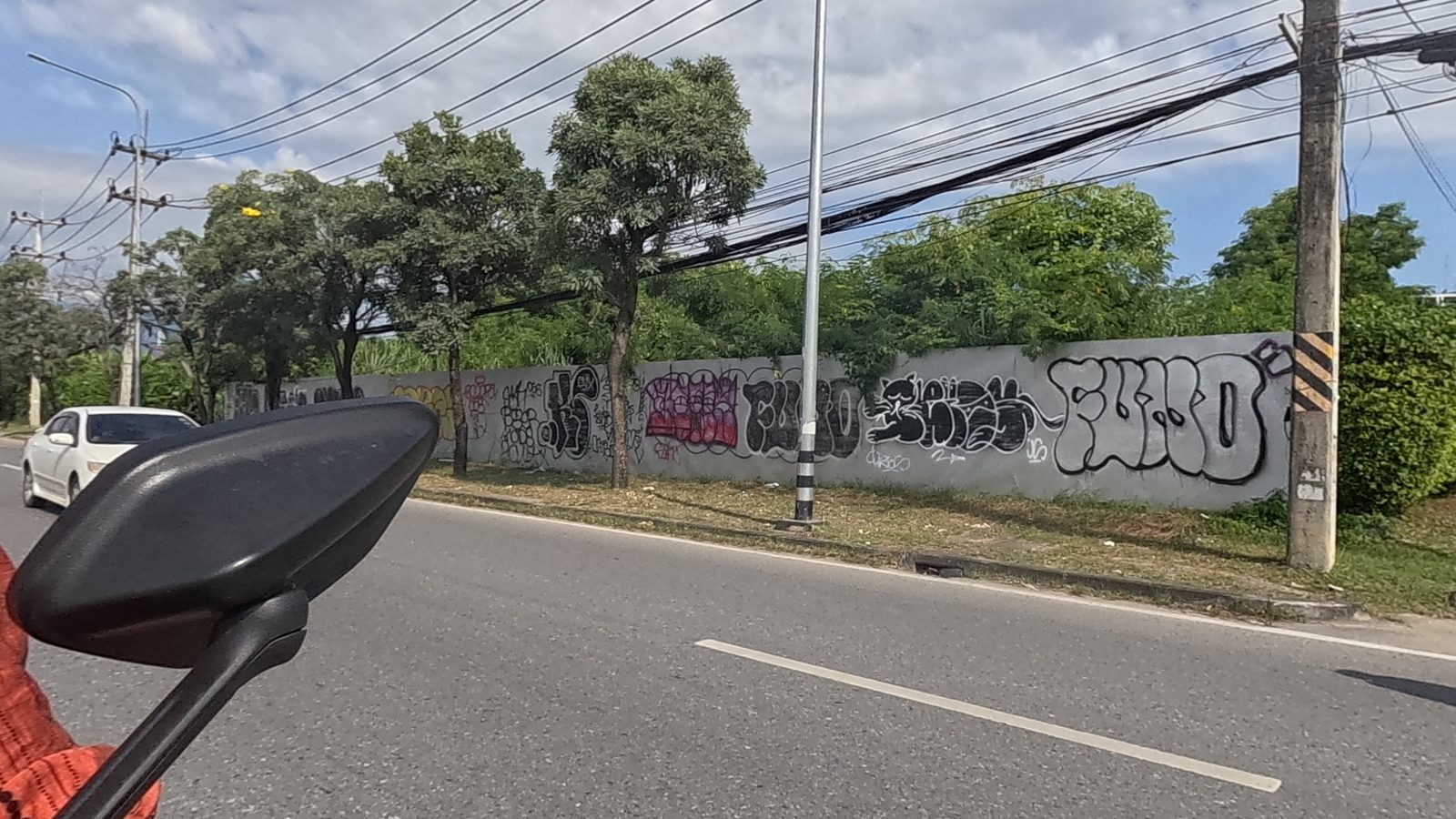 long tagged boundary wall reading FURO