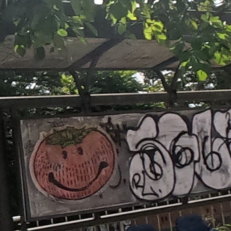 Smiling cartoon fruit character on bus shelter panel
