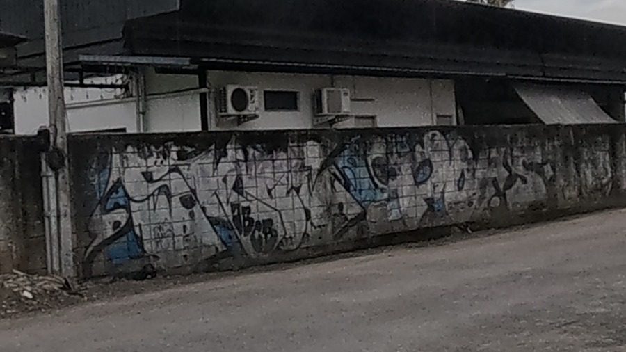 Black and blue throw-up tags on a low wall by the old city moat