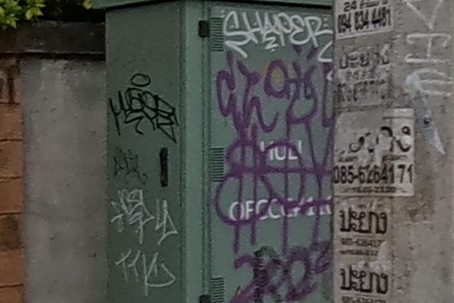 Green utility cabinet covered in purple and black tags