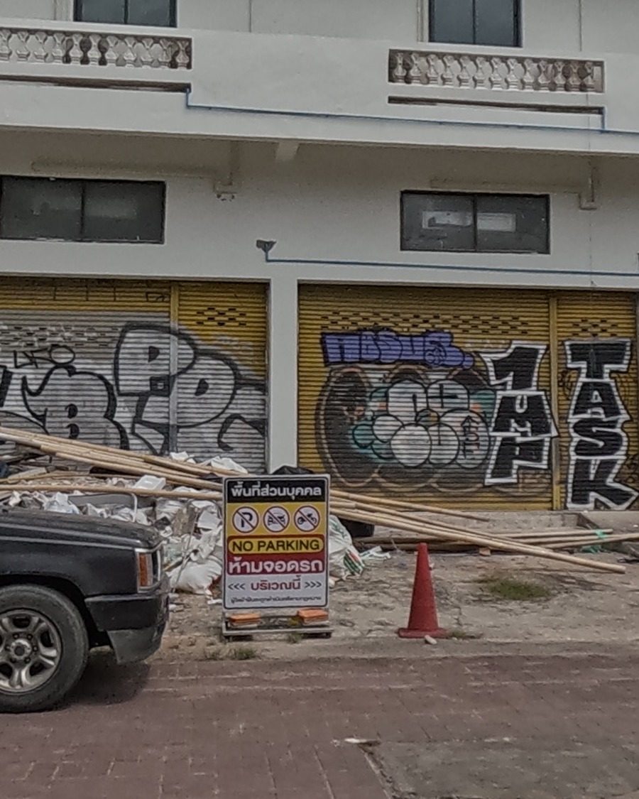 Bubble-letter tags TASK and 1UP on shop shutters