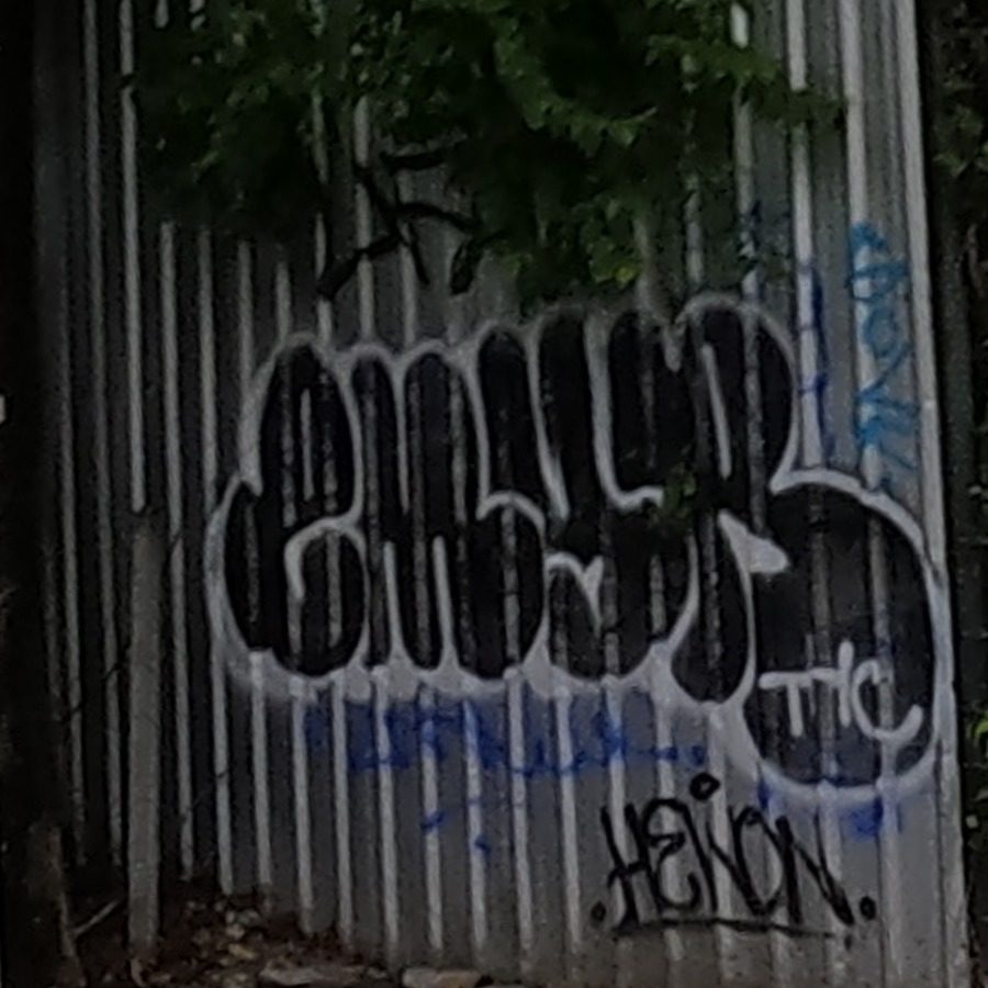 Corrugated fence graffiti: bubble tag with THC and HELON tags