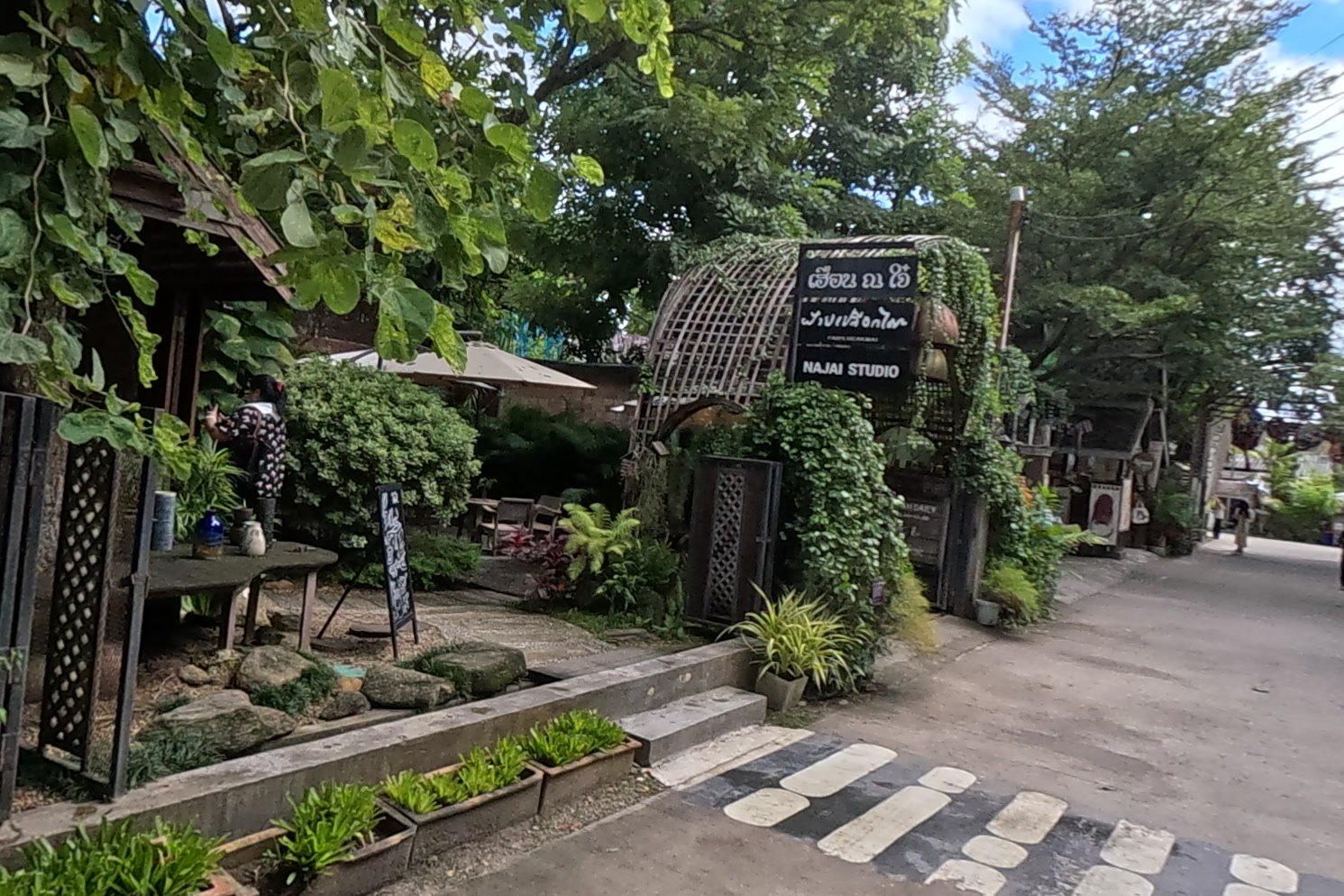NAJAI Studio entrance through a vine arch — Chamcha Market, San Kamphaeng