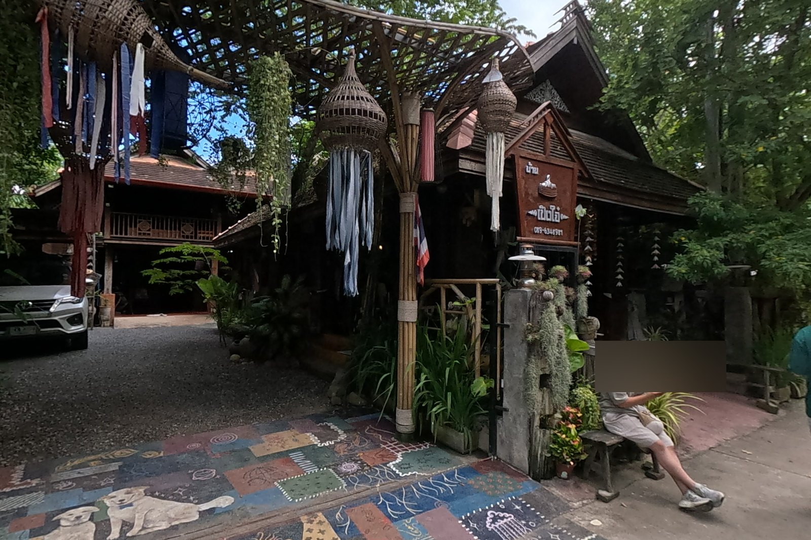 Baan Pengjai's bamboo gateway and painted drive — Chamcha Market, San Kamphaeng
