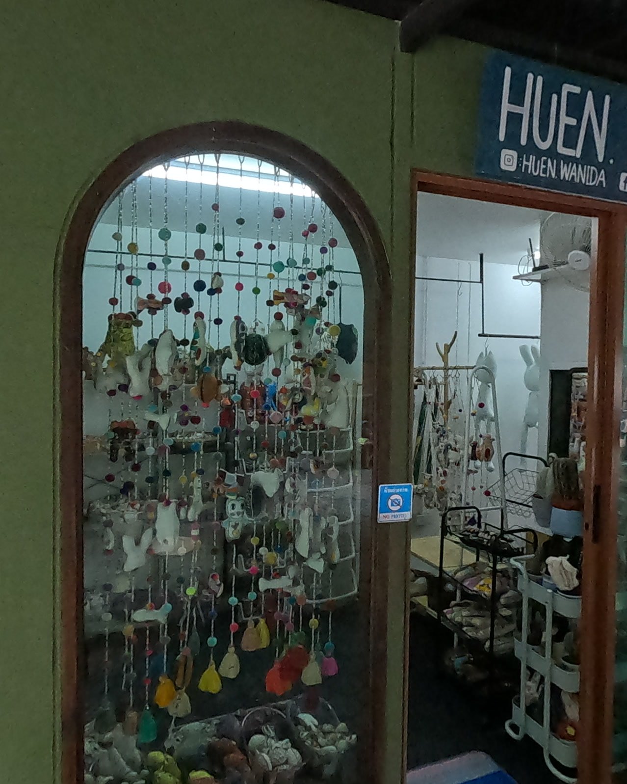 Fabric mobiles in the arched windows of HUEN WANIDA — Chamcha Market, San Kamphaeng