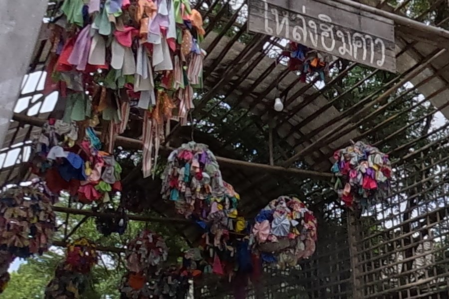 Fabric-flower balls under the Loanghimkao arch — Chamcha Market, San Kamphaeng