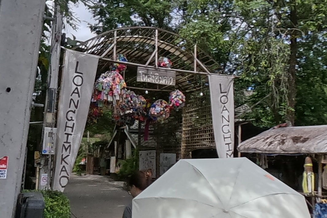 The โหล่งฮิมคาว arch with LOANGHIMKAO banners — Chamcha Market, San Kamphaeng