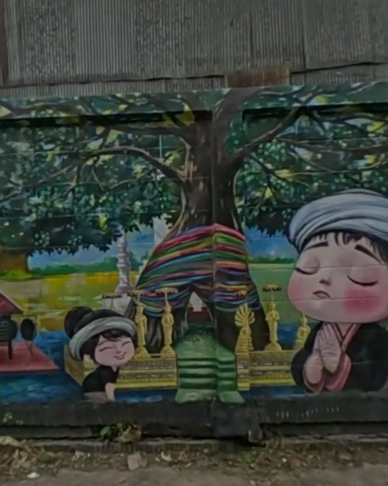 Mural: child praying by a spirit house and sacred tree — San Kamphaeng