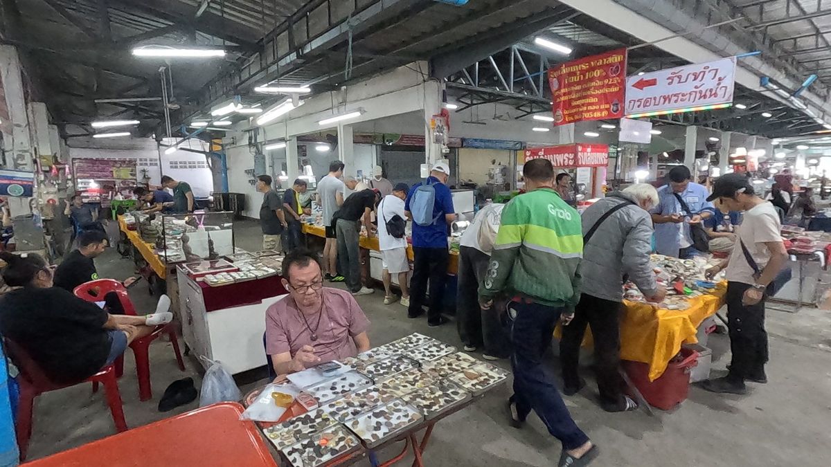 ผู้ซื้อรุมดูโต๊ะพระเครื่อง · Buyers crowd the amulet tables